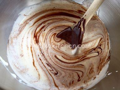 Mescolare il cioccolato fuso e il burro al composto di uova e zucchero per preparare la torta al cioccolato.